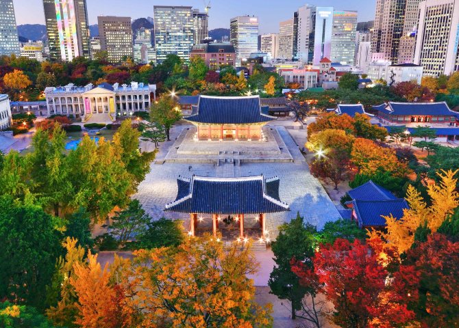 Autumn view of Deoksugung Palace surrounded by city buildings